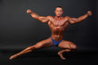Photo: Bodybuilder posing on dark background. Bodybuilder posing on dark background.