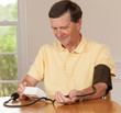 Senior man taking blood pressure at home