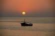 Photo: Sunset over the ocean with a boat Sunset over the ocean with a boat