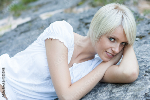 Photo: Hübhsche Frau liegt auf Felsen Hübhsche Frau liegt auf Felsen