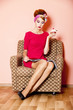 Style girl in red dress sitting in armchair with cake and magazi