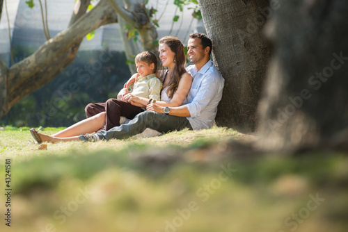 Photo: Happy family in city gardens relaxing during holidays Happy family in city gardens relaxing during holidays