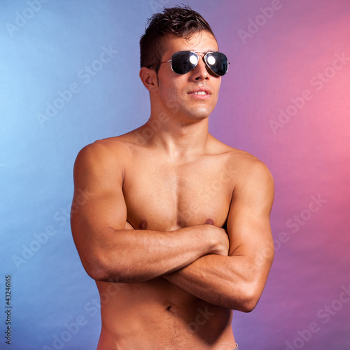 Photo: Handsome man on studio with glasses and arms crossed Handsome man on studio with glasses and arms crossed
