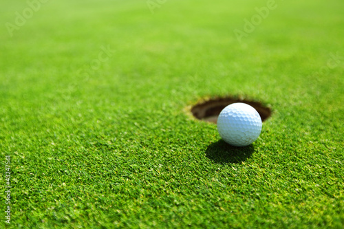 Photo: golf ball on lip of cup golf ball on lip of cup