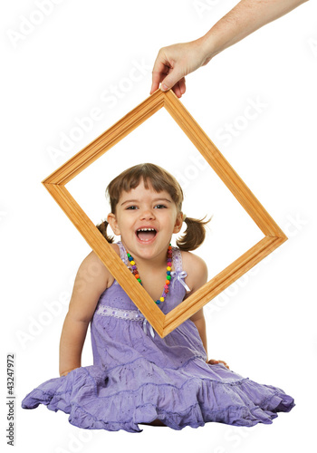 Photo: Happy little girl looking through the frame Happy little girl looking through the frame