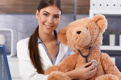 Photo: Young doctor examining soft toy Young doctor examining soft toy