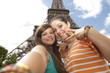 Photo: 2 jeunes filles se prenant en photo devant la Tour Eiffel 2 jeunes filles se prenant en photo devant la Tour Eiffel
