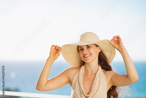 Photo: Smiling woman on vacation standing on balcony Smiling woman on vacation standing on balcony