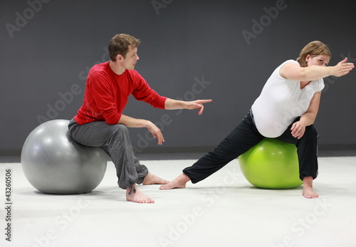 Foto: pregnant woman with personal trainer on large stability balls pregnant woman with personal trainer on large stability balls