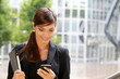 Femme d'affaire arrivant au bureau en checkant ses mails