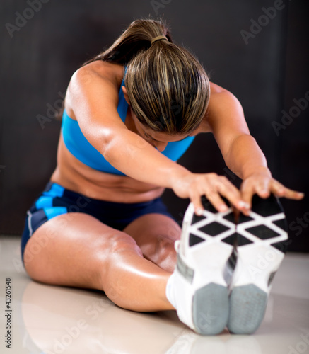 Photo: Athlete stretching legs Athlete stretching legs