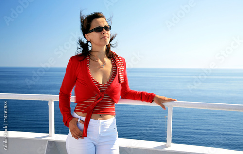 Photo: Young woman in cruise on liner seascape background Young woman in cruise on liner seascape background