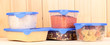 Filled plastic containers on wooden background