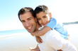 Father holding son on his shoulders at the beach