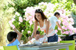 Mother serving lunch to kids in home garden