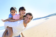 Foto: Daddy carrying children on his back at the beach Daddy carrying children on his back at the beach