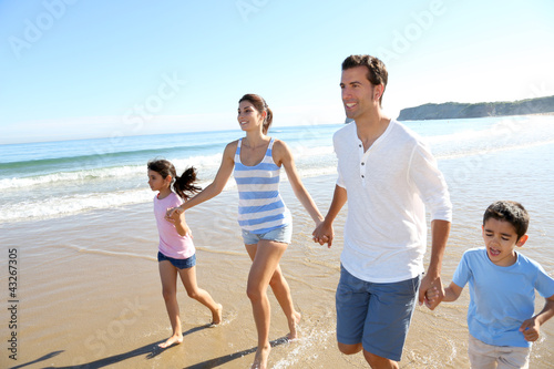 Foto: Family having fun running on the beach Family having fun running on the beach
