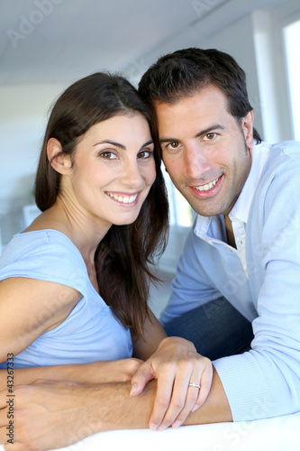 Photo: Closeup of cheerful couple sitting in sofa Closeup of cheerful couple sitting in sofa