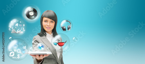 Foto: Pretty business woman holding tablet computer and different obje Pretty business woman holding tablet computer and different obje