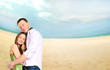 Portrait of young couple in love embracing at beach and enjoying