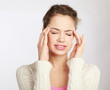 A young woman with a headache holding head