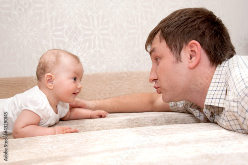Photo: Father and baby daughter, talking, smiling Father and baby daughter, talking, smiling