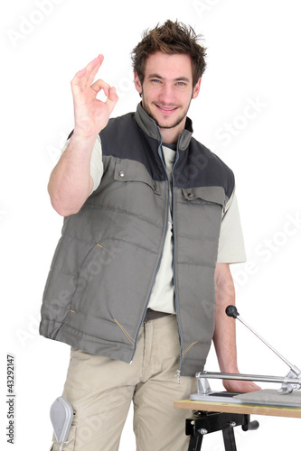 Photo: portrait of young tiler making okay sign portrait of young tiler making okay sign