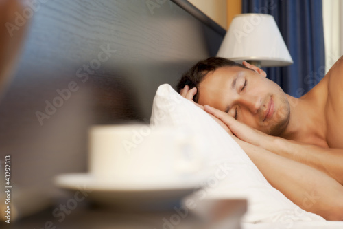 Photo: man sleeping on a bed. morning tea man sleeping on a bed. morning tea