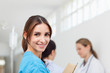 Smiling woman  while standing in a hallway with a patient and a