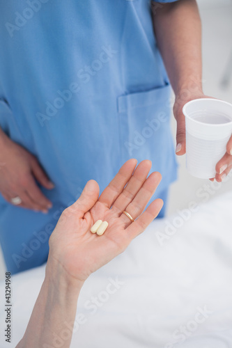 Foto : Nurse giving plastic glass to a patient Nurse giving plastic glass to a patient