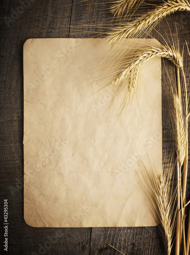 Photo: wheat on the old wooden table and old paper wheat on the old wooden table and old paper