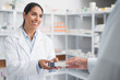 Smiling pharmacist giving a box to a doctor