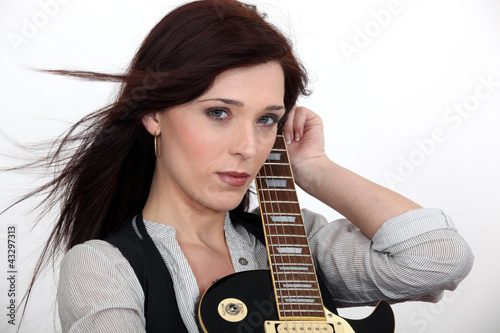 Photo: Serious woman hugging her guitar Serious woman hugging her guitar