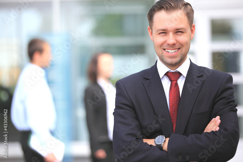 Photo: Happy smart business man with team mates discussing Happy smart business man with team mates discussing