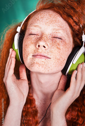 Foto: portrait of a young girl listening to music with headphones portrait of a young girl listening to music with headphones