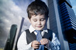Foto: child dressed businessman with hands in his tie and skyscrapers child dressed businessman with hands in his tie and skyscrapers
