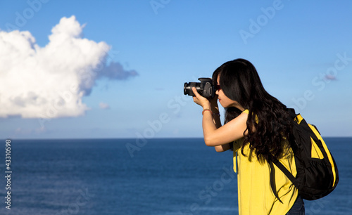 Photo: Young woman taking photo with cloud background Young woman taking photo with cloud background