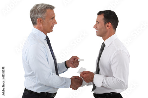 Photo: duo of businessmen exchanging visit cards duo of businessmen exchanging visit cards