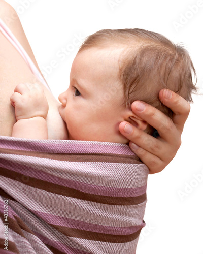 Photo: Tiny newborn baby girl breastfeeding, settling in a sling Tiny newborn baby girl breastfeeding, settling in a sling