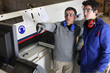 Two men operating factory machine