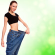 attractive young woman shows her old huge pair of jeans