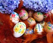 Easter eggs in a basket with colorful feathers