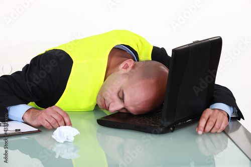 Foto: Exhausted man sleeping on his laptop Exhausted man sleeping on his laptop