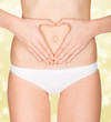 Hands on female belly, golden blurred background