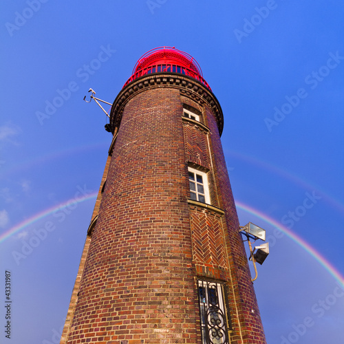 Foto: Leuchtturm mit Regenbogen im Hintergrund Leuchtturm mit Regenbogen im Hintergrund
