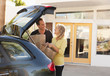 Caucasian couple removing groceries from car