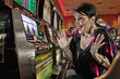 Excited Caucasian woman playing slot machines in casino