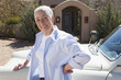 Caucasian woman leaning on car in driveway