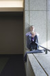 Caucasian businessman relaxing on office ledge