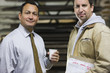 Foreman and worker standing in factory